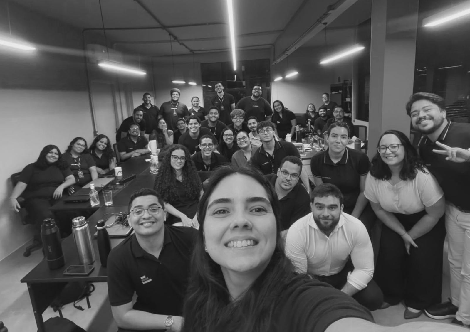 Time da Liberdata reunido no escritório, em preto e branco.