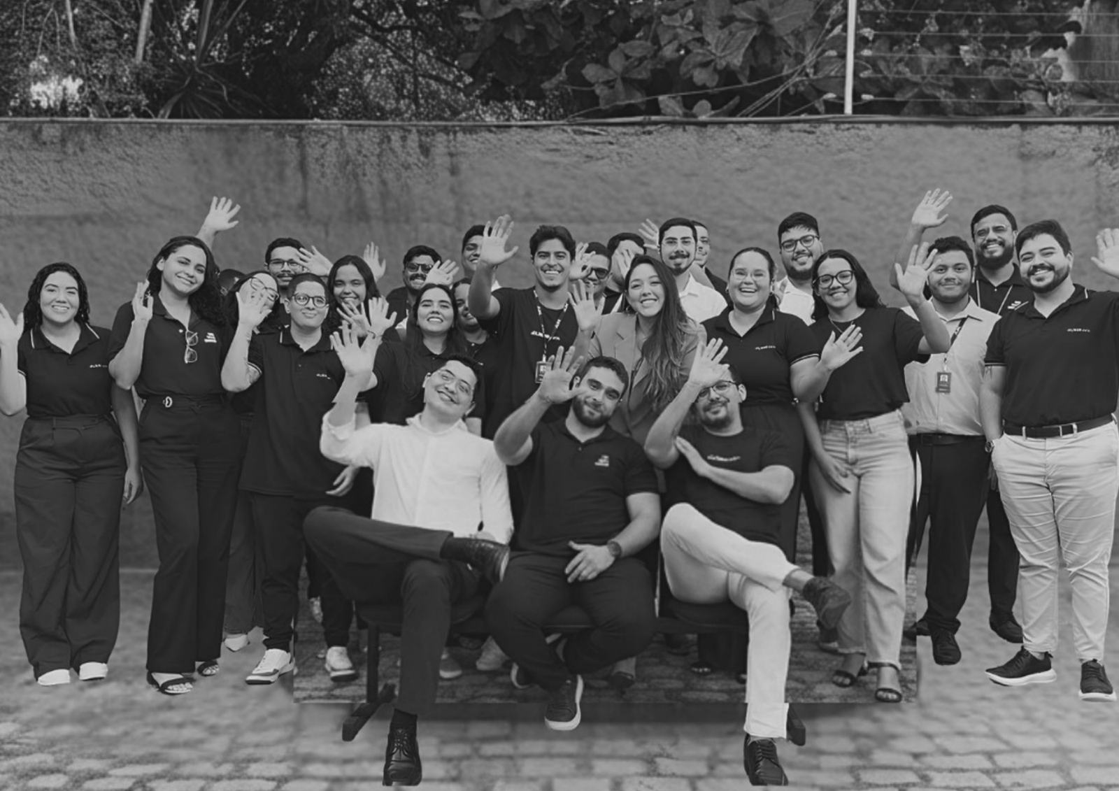 Consultores da Liberdata reunidos ao ar livre, acenando.